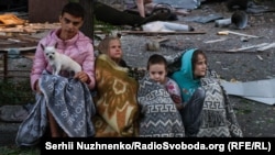 Children gather near the site of a Russian missile attack in Kyiv on August 28.