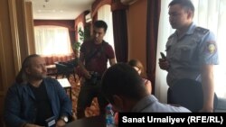 Инспекторы миграционной полиции составляют протокол на журналиста из Украины Александра Гороховского (слева). Уральск, 15 сентября 2018 года.     