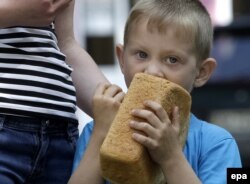 Мальчик ест хлеб, выданный как гуманитарная помощь, Донецк, 3 июня 2015 года
