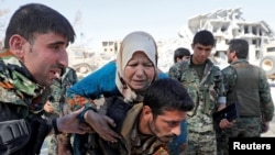 Сирия Демократиялык күчтөрү жергиликтүү тургунду Ракканын бошотулган стадионунан чыгарууда. 17-октябрь, 2017-жыл.