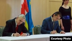 Глава Ліги українців Канади Орест Стеців (ліворуч) і президент Канадської асоціації кримських татар Рустем Ірсай підписують 24 березня цього року меморандум про співпрацю