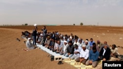 Türkiýeli kürtler serhede golaý açyk meýdanda raýdaşlyk namazyny okaýarlar. 10-njy oktýabr, 2014.