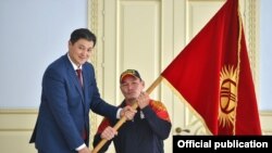 Улукбек Марипов спортчу Арстанбек Базаркуловго кыргыз желегин тапшырды.