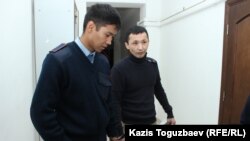 Конвойдың Әсет Нұржаубайды кісенмен сотқа әкелген кезі. Алматы, 20 қыркүйек 2018 жыл  