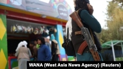 A Taliban soldier carrying a rifle stands in an amusement park in Kabul. (file photo)