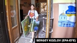 Дівчина виносить картини з будинку культури в місті Чугуєві, який постраждав від обстрілу російських військових. Чугуїв, Харківщина, 25 липня 2022 рок