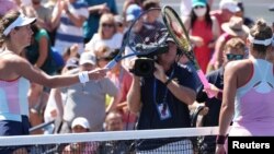 Marta Kostyuk of Ukraine (right) used a racquet touch instead of a handshake after losing to Victoria Azarenka of Belarus (left) at the U.S. Open in New York.