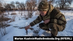 Український військовий по дорозі у село Катеринівка перевіряє, чи не замінована територія