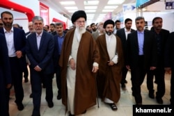 مسعود خامنه‌ای در کنار پدرش در بازدید از نمایشگاه کتاب تهران