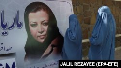 Парламент депутаттыгына талапкер Мария Баширдин сүрөтүн карап турган аялдар. Герат, 30-сентябрь, 2018-жыл.  