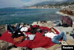 Африканські мігранти, що хочуть потрапити з Італії у Францію, сплять на березі, червень 2015 року