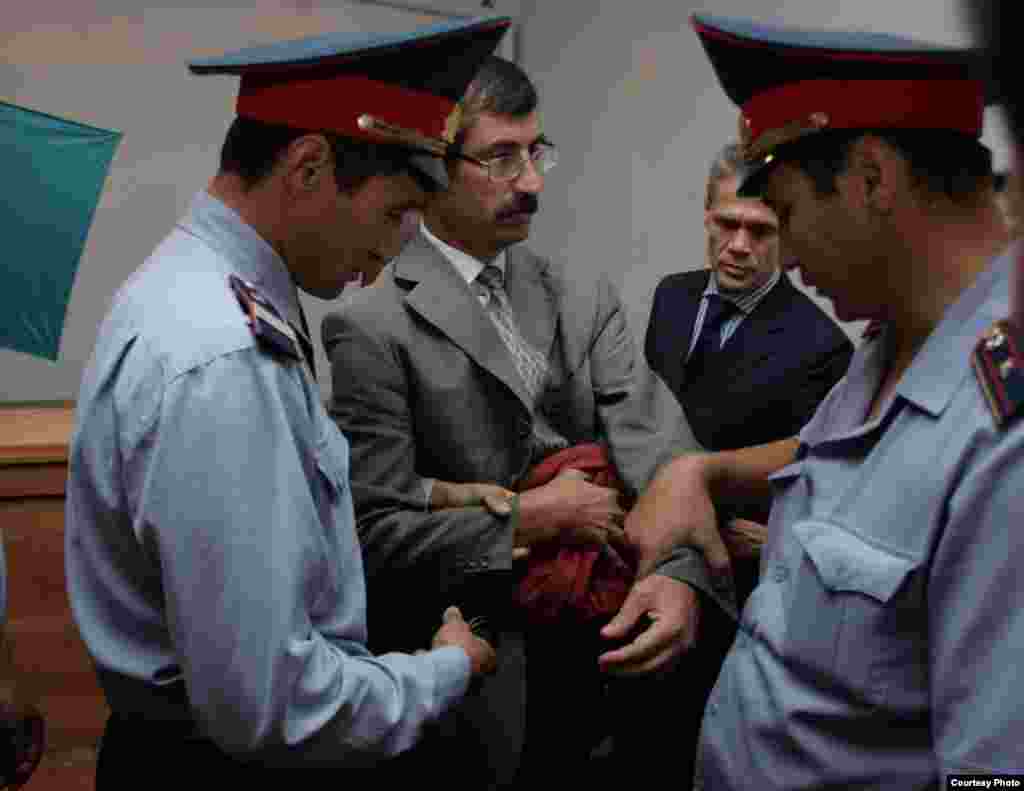 Евгений Жовтиске сот залында кісен салынды.  - Полиция қызметкерлері Евгений Жовтисті қолына кісен салып сот залынан алып кетті. Сурет  "Свобода слова" газетінен алынды.