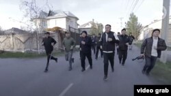 Жеңишбек Токторбаев Ошто кызматкерлер менен көчөнү кыдырып жүргөн учур. Сергей Лапушкин оң жактан эң четте фотоаппарат көтөрүп баратат.