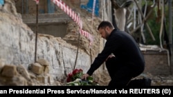 Украинският президент Володимир Зеленски отдава почит на загиналите при срутването на поразен от руски удар на 17 юни жилищен блок в Киев, 19 юни 2025 г.