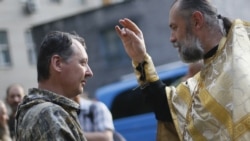 Священник Московського патріархату благословляє російського полковника Ігоря Гіркіна (Стрєлкова), який на той час був одним з ватажків групи «ДНР». Окупований Донецьк, 10 липня 2014 року