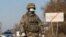 KAZAKHSTAN -- A Kazakh serviceman wearing a protective mask stands guard at a check point, following the state emergency commission's decision to lock down Almaty to prevent the spread of coronavirus disease (COVID-19), on the outskirts of Almaty, Kazakhs