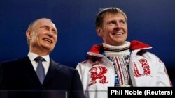 Президент Роcії Володимир Путін і бобслеїст Олександр Зубков на церемонії закриття Олімпійських ігор у Сочі в 2014 році