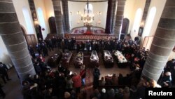 Armenia -- People surround coffins with the bodies of six murdered people during a funeral ceremony in Gyumri, January 15, 2015