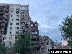 У результаті бомбардувань частина житлового будинку у Маріуполі обвалилася, літо 2022 року