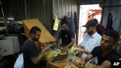 Палестинци пекат хляб, след като Световната продоволствена програма успя да внесе брашно за първи път от повече от месец насам, след като Израел позволи на някои помощи да влязат в Ивицата Газа, 22 май 2025 г.