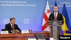 Премьер-министр Грузии Ираклий Гарибашвили выступает после президента Украины Петра Порошенко во время церемонии подписания соглашения о сотрудничестве с Евросоюзом. Брюссель. 27 июня 2014 года.