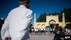 Мужчина у мечети в Кашгаре, июнь 2017 года.