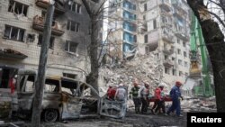 Разбор завалаў на месцы разбуранай сэкцыі дзевяціпавярховіку ў Кіеве