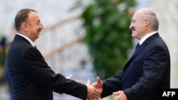 Belarus -- Belarussian President Alexander Lukashenko (R) shakes hands with Azerbaijan's President Ilham Aliyev during the Commonwealth of Independent States (CIS) leaders summit in Minsk on October 10, 2014. AFP PHOTO/MAXIM MALINOVSKY