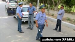 Ýol polisiýasynyň ofiseri ulag eýesiniň 'düşündirişini' diňleýär. Arhiw suraty