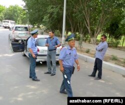 Polisiýanyň Ýol gözegçiligi gullugynyň işgärleri sürüjini saklaýar. Bezeg suraty. Türkmenistan