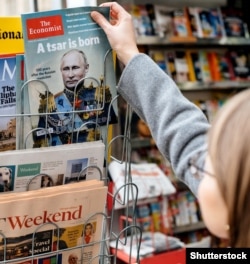 Жінка купує в газетному кіоску журнал The Economist із зображенням на обкладинці президента Росії Володимира Путіна із заголовком «Народився цар». Франція, Страсбург, 28 жовтня 2017 року