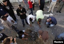 У місті Ашдод на півдні Ізраїлю розглядають місце, де влучила палестинська ракета, 16 листопада 2012 року