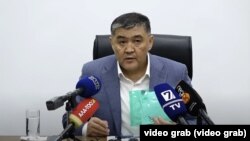 Камчыбек Ташиев сөз болуп жаткан катты көрсөтүүдө.