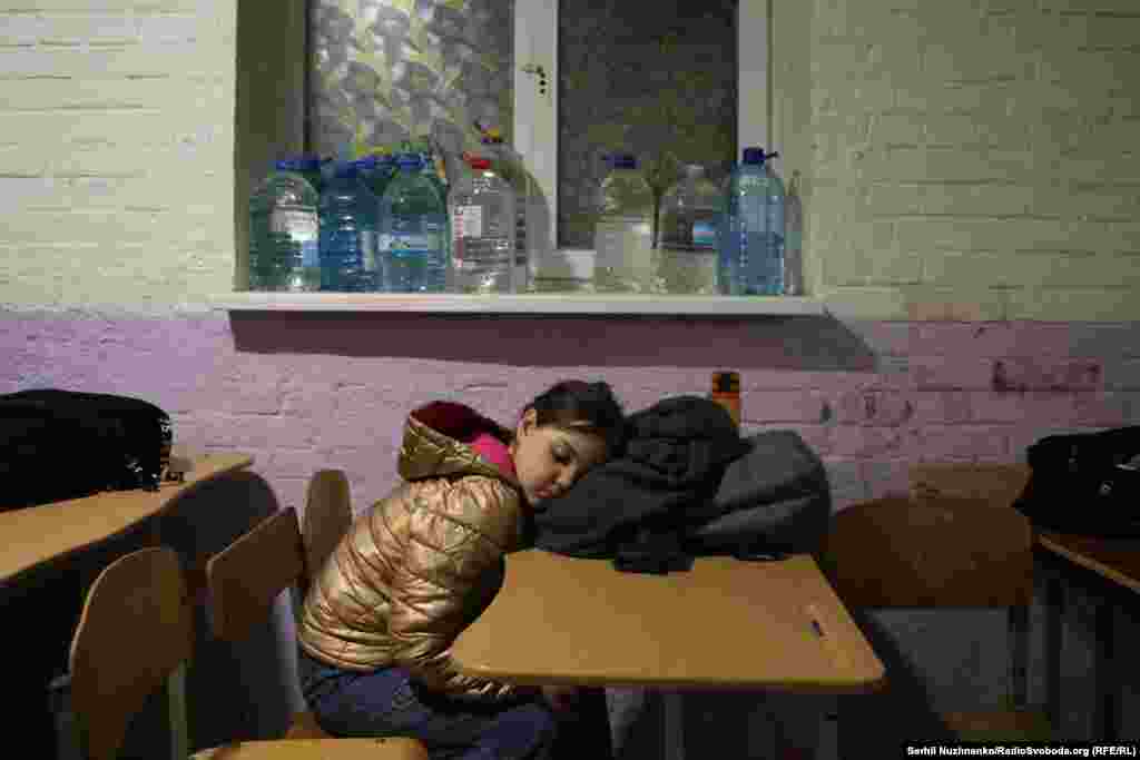 Дитина спить за столом в укритті