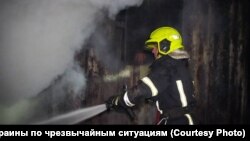 Рятувальник гасить пожежу після повітряного удару, фото ілюстративне
