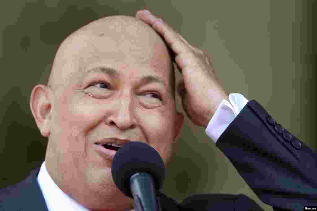 Уго Чавес рак илдетинен дарылануу үчүн чачын алдыргандан кийин башын сылап, тамаша кылууда