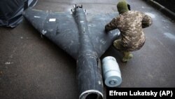 Украинский военный осматривает сбитый ранее беспилотник Shahed с термобарическим зарядом, запущенный Россией, 14 ноября 2024 года