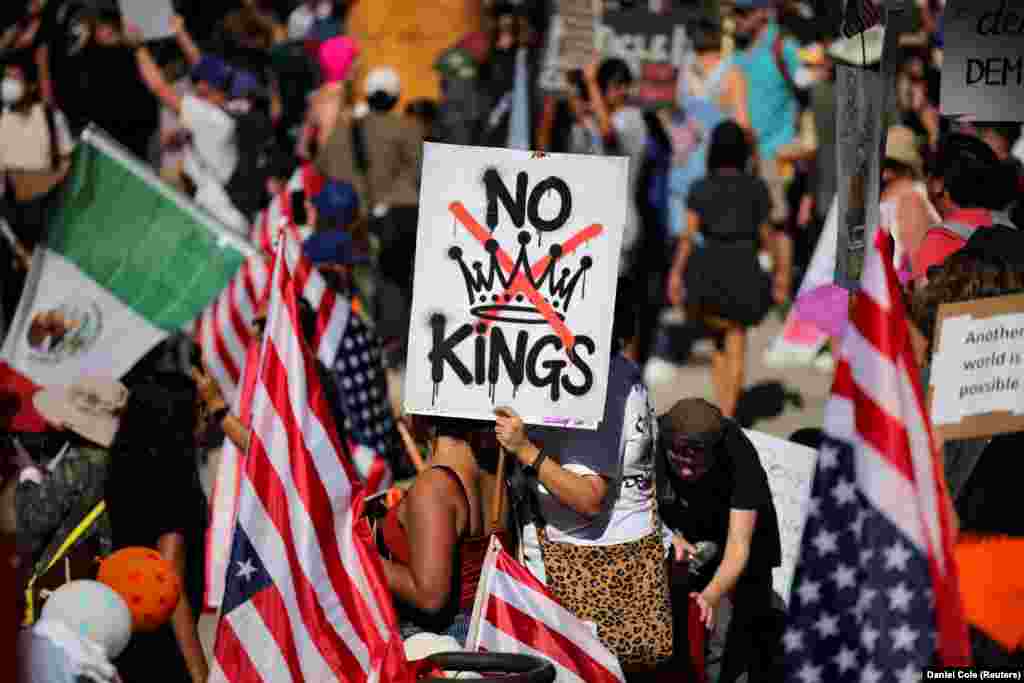 Протестувальниця тримає плакат з написом «Ні королям» та зображенням перекресленої корони під час акції протесту проти політики президента США Дональда Трампа біля мерії в Лос-Анджелесі, Каліфорнія, США, 18 жовтня 2025 року