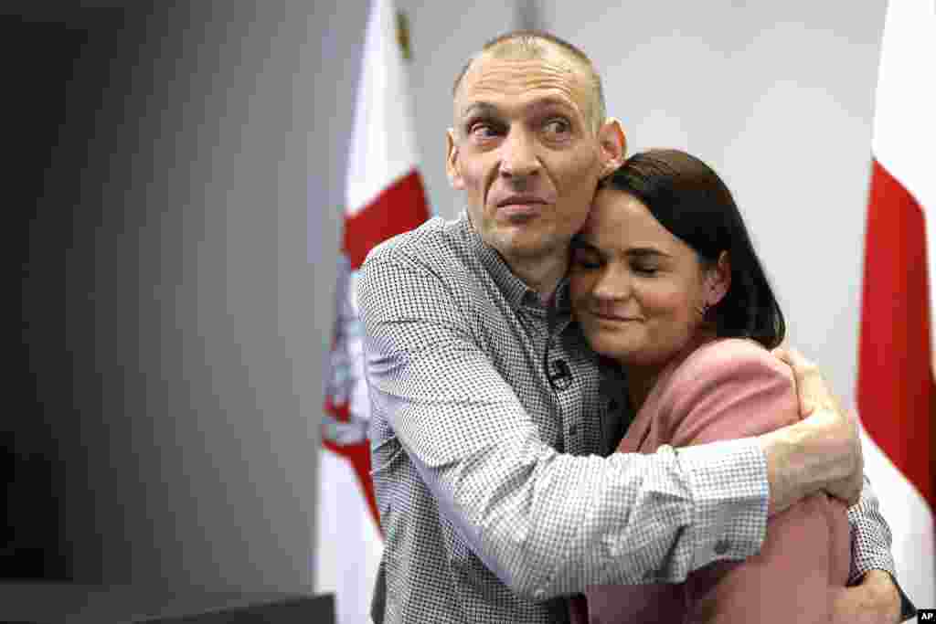 Сергей Тихановский, белорусский оппозиционный активист, освобожденный из тюрьмы, обнимает свою жену, лидера белорусской оппозиции Светлану Тихановскую, Вильнюс, Литва, 22 июня 2025 года. AP Photo/Mindaugas Kulbis