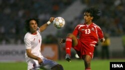 جواد نکونام، کاپیتان تیم ملی فوتبال ایران، در جدال با یک بازیکن اماراتی در بازی های مرحله مقدماتی جام جهانی آفریقای جنوبی