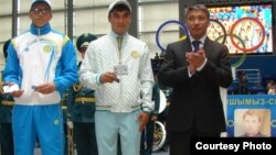 Казахстанские спортсмены (слева) и руководитель агентства спорта и физической культуры Казахстана Талгат Ермегияев во время вручения удостоверений участников Олимпиады в Лондоне. Астана, июль 2012 года.  