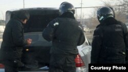 Полицейские проводят досмотр машины. Жанаозен, 19 декабря 2011 года. Фото Елены Костюченко, "Новая газета".