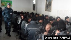 Сотрудник женской колонии смотрит за заключенными во время обеда в столовой учреждения.  