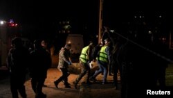 Співробітники екстреної служби несуть тіло на місці російського ракетного удару в житловому районі, Кривий Ріг, Україна, 4 квітня 2025 року