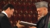 Afghan President Hamid Karzai (right) and his Turkmen counterpart, Gurbanguly Berdymukhammedov, exchange one of their agreements in Kabul