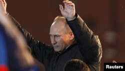 Владимир Путин приветствует своих сторонников на митинге на Манежной площади. Москва, 4 марта 2012 года.    