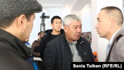 Житель города Жанаозена Нурлыбек Нургалиев (в центре) в коридоре акимата Жанаозена беседует с  руководителем аппарата акима Бекжаном Ауэзовым. Жанаозен, 18 февраля 2020 года.