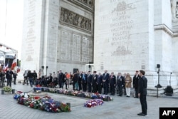 Президентът на Франция Еманюел Макрон (вдясно) по време на церемонията на Триумфалната арка, след като е положил венец на Гроба на незнайния войн.