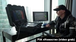 Станіслав Орлов з позивним «Испанец» біля російського програмно-апаратного комплексу «Орбіта» у діловому центрі «Москва-Сити»