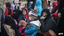 Qaçaqlar yardım almaq içün sırağa tizile. Suriye, şimaliy-ğarbiy region, 2019 senesi dekabrniñ 23-ü. Nümüneviy resim